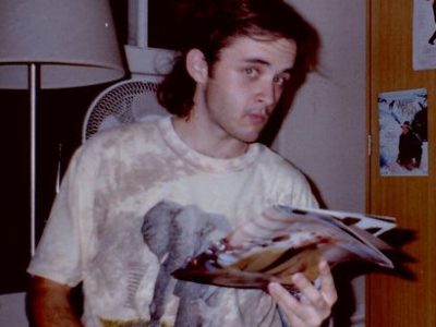 Glenn in 1992, reading magazine and eating Twizzlers